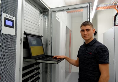 Lernender stehend vor einem Laptop Lernender stehend vor einem Laptop